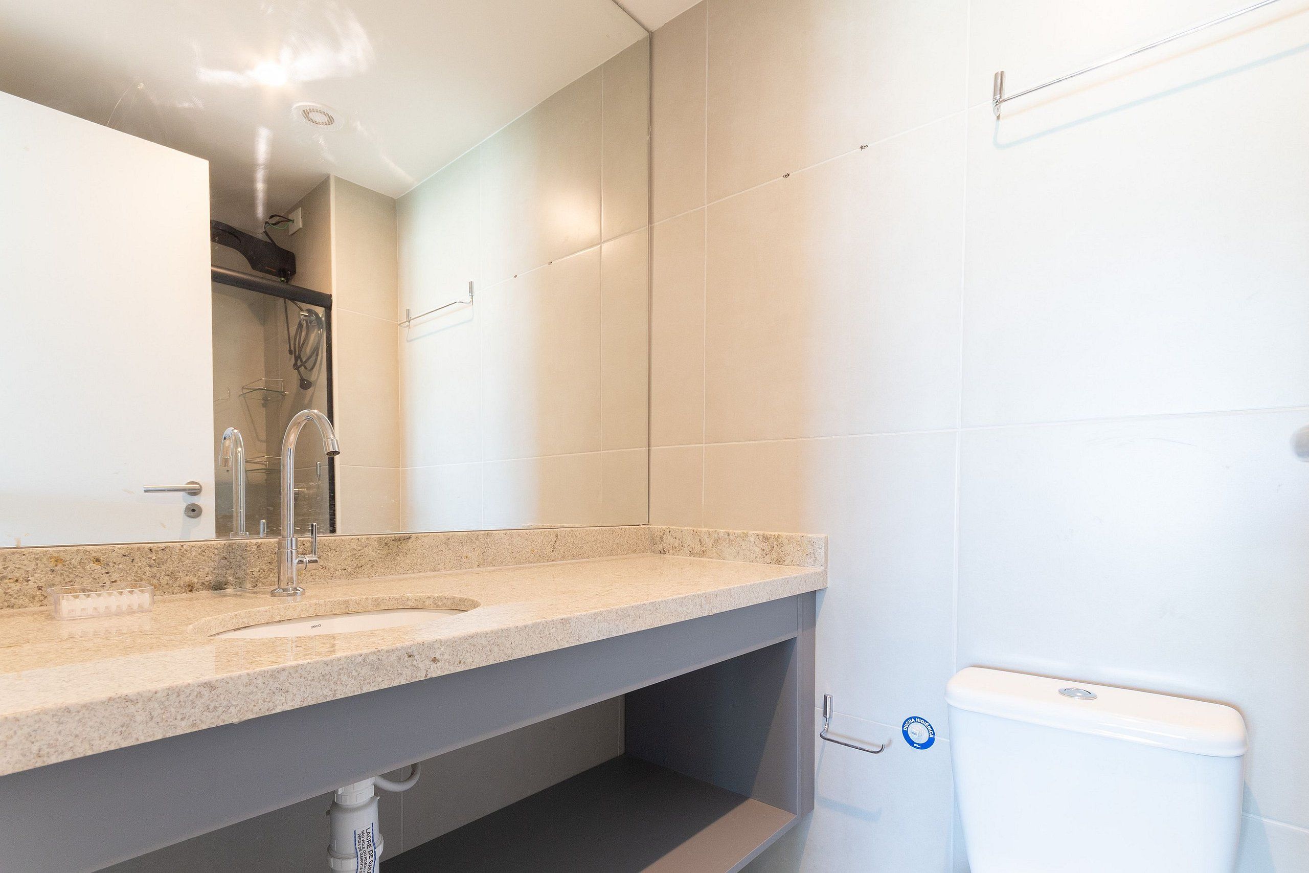 A bathroom with a sink, mirror, and toilet.