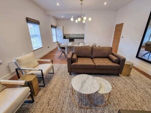 A modern living room with a sofa, armchairs, and a coffee table.