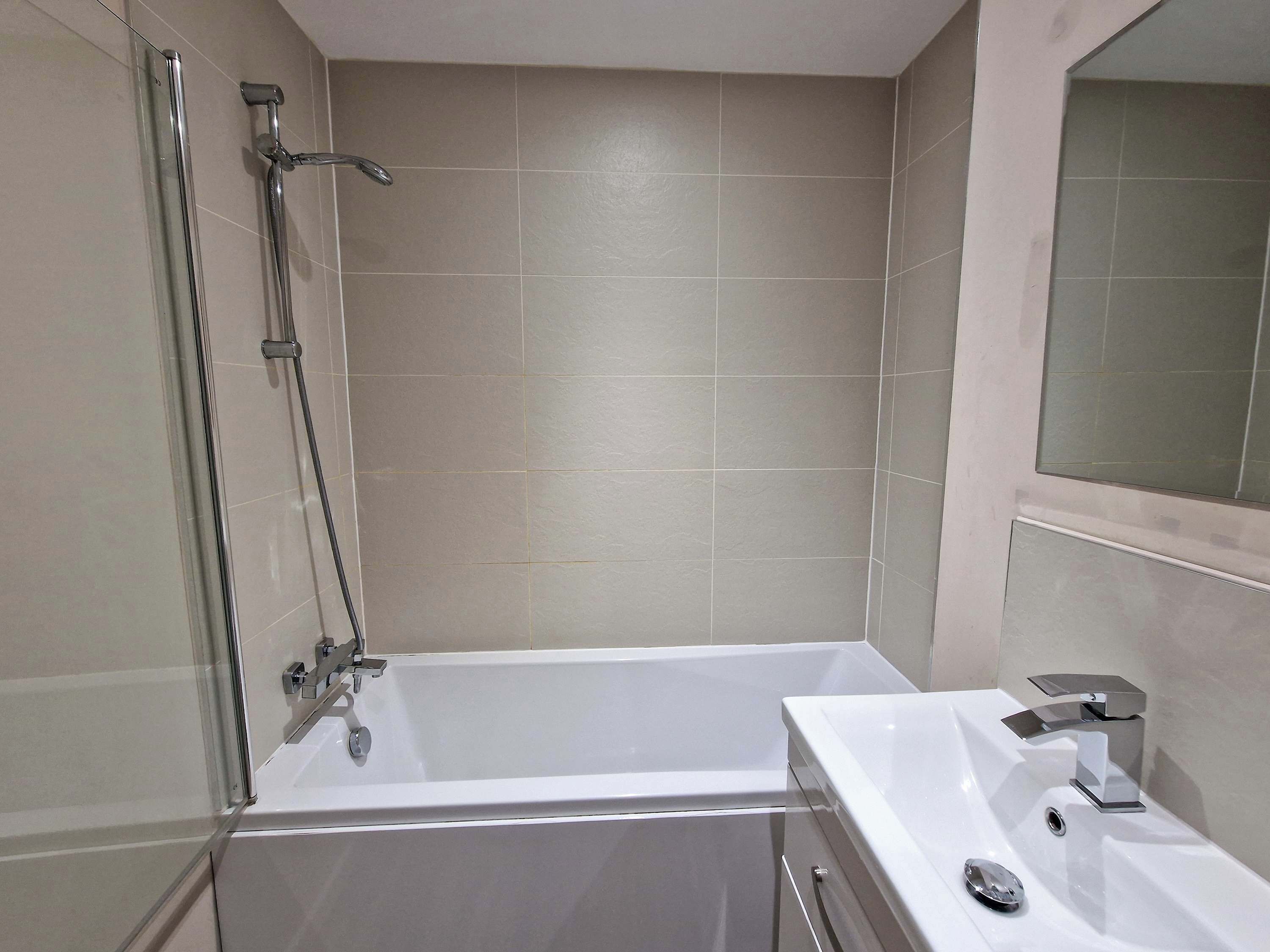 Une salle de bain moderne avec une baignoire, une douche et un lavabo.