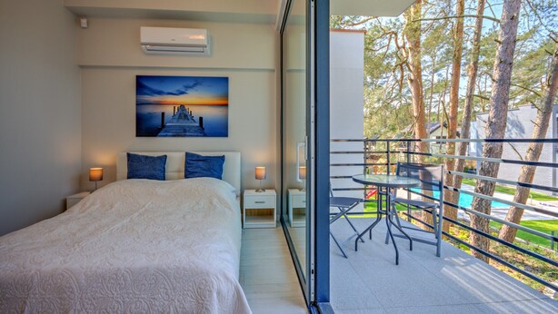 Une chambre à coucher avec un grand lit, des tables de chevet et un tableau au mur.