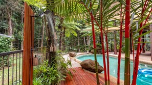 An indoor pool area surrounded by lush greenery and bamboo structures. - Fern House your serene rainforest retreat (Bingil Bay)