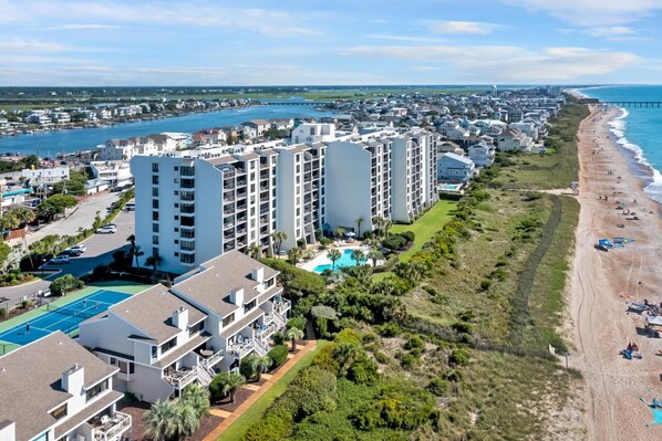 A coastal hotel with multiple buildings, a beach, and a view of the ocean.