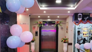 Un'accogliente hall d'albergo con tappeto rosso, reception e scala.