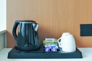 Una cafetera, una taza y una caja de GINNA sobre una bandeja.