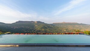 A swimming pool with a view of a mountainous landscape. - Villa 199 Amarja's Sunset Retreat (Mawal)