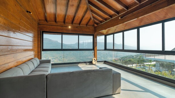 A modern interior with a wooden ceiling, large windows, and a grey sectional sofa. - Villa 199 Amarja's Sunset Retreat (Mawal)