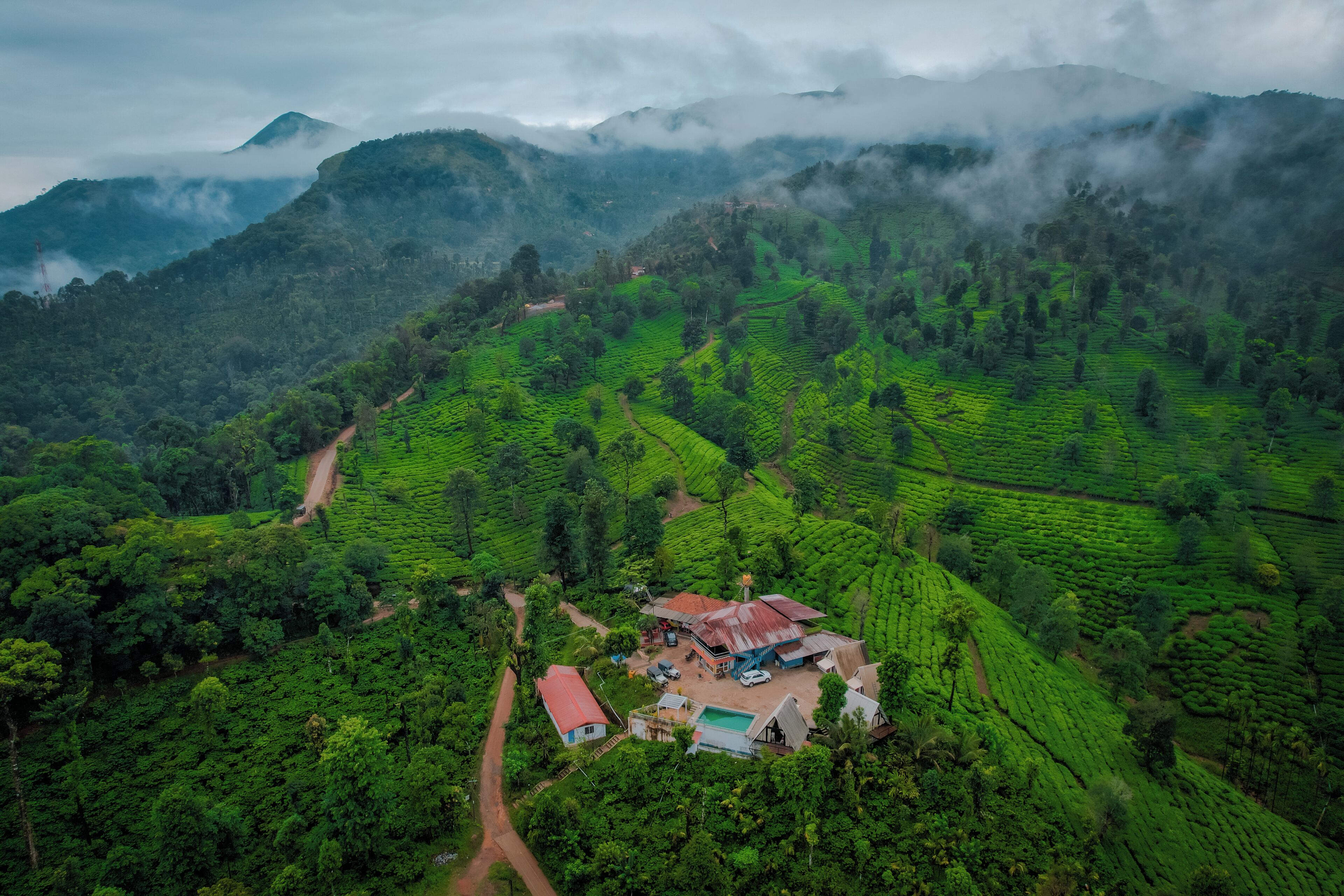 A rural landscape with terraced fields, a small house, and a road.