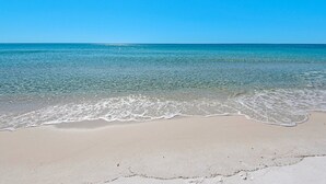 A beach with clear water and a sandy shore.
