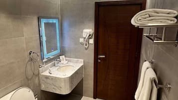 Deluxe kamer | Badkamer | Een haardroger, pantoffels, handdoeken, zeep