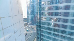 Un grattacielo moderno con facciata in vetro e un'intersezione trafficata sottostante.