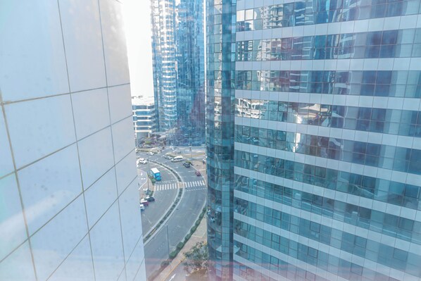 A high-rise building with a modern glass facade and a busy intersection below. - Bloomfields Classic STU in Hydra Al Reem (Abu Dhabi)