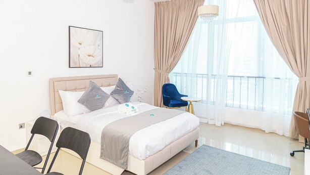 Una camera d'albergo moderna con un letto grande, una scrivania e una sedia.