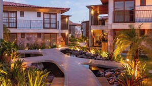 A resort with multiple buildings, a stone bridge, and landscaped gardens.