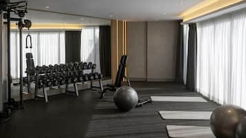 Uma academia moderna com equipamentos de ginástica, tapetes de yoga e uma grande bola de exercícios.