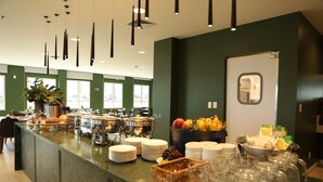 Un buffet proposant une variété de plats, d’assiettes et de verres.