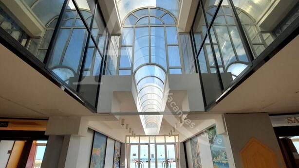 A modern atrium with a glass ceiling, allowing natural light to illuminate the space. - CAP CORNICHE - Studio cabine terrasse, clim, internet et parking (Sète)