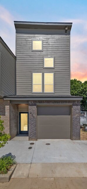 A two-story house with a garage, a front door, and a small porch area.
