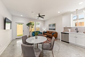 A modern kitchen with white cabinets, a stainless steel dishwasher, and a black faucet.