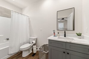 Een moderne badkamer met toilet, douche en wastafel.