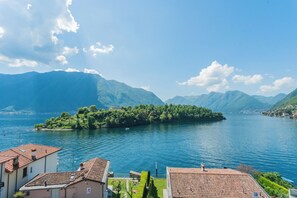 Blick auf einen See mit Gebäuden und Bergen im Hintergrund.