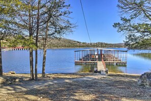 A dock extending into a calm lake, surrounded by trees and a clear sky. - Table Rock Lake Condo w/ Sunrise Views & Pool (Kimberling City)