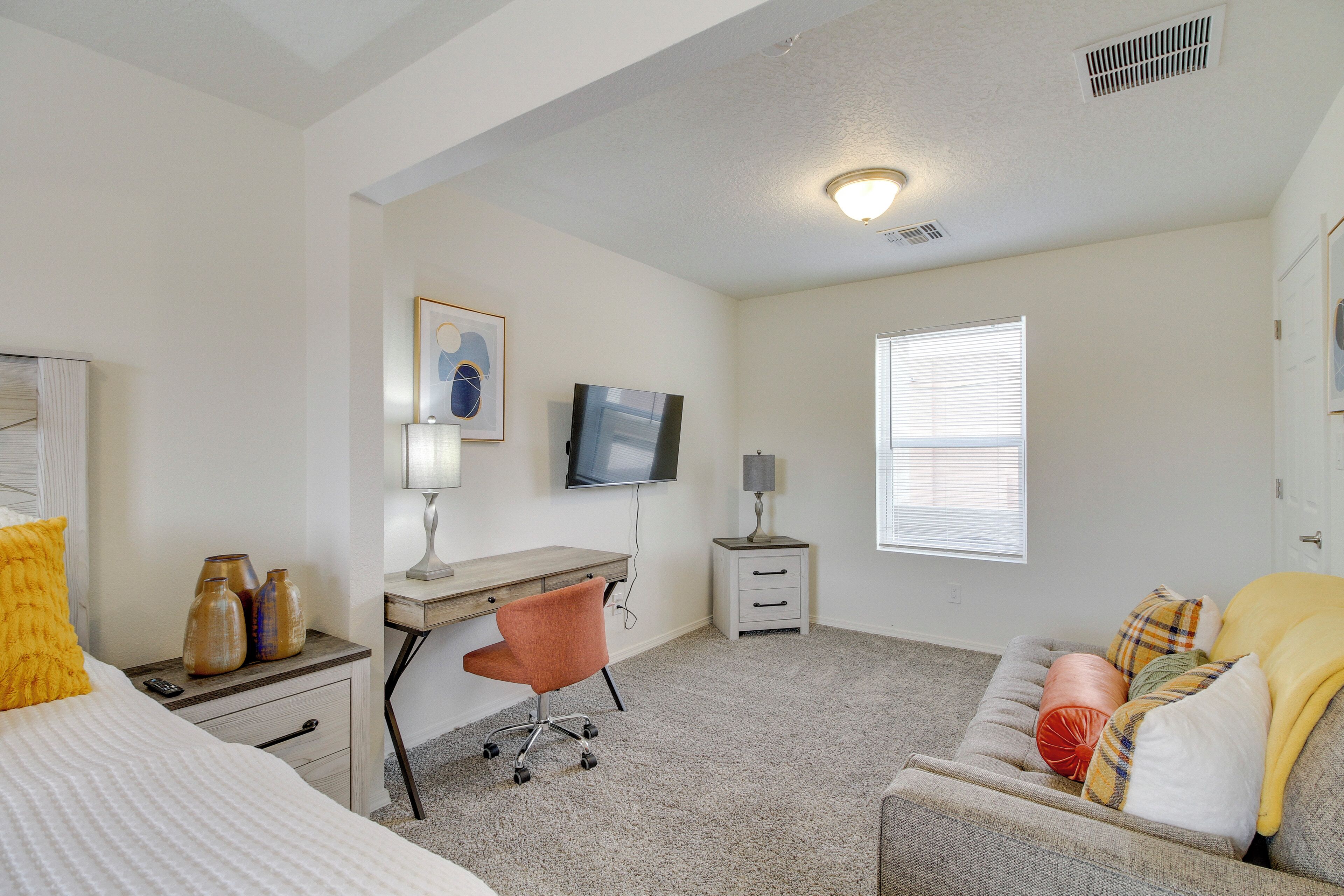 Une chambre à coucher avec un lit, un bureau, une chaise et un canapé.