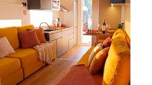 A compact living space with a sofa, a small kitchen area, and a television. - Exclusive Boat in Vigo Marina | Private Terrace over the Sea (Vigo)