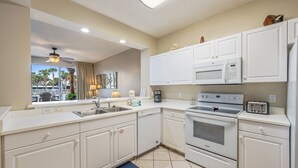 Una cocina moderna con armarios blancos, un microondas, un horno y un tostador.