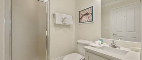 A bathroom with a toilet, sink, and shower.