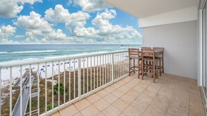 Un balcon avec vue sur la plage et l’océan.
