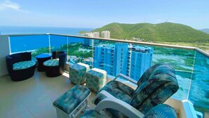 Un balcone con piscina, area salotto esterna e vista sulla città e sulle colline.