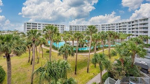 Un hotel con varias plantas, piscina y palmeras.