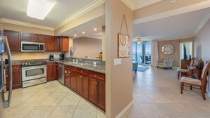 A spacious kitchen with granite countertops, stainless steel appliances, and wooden cabinets. - H602 Top-Floor 3BR Bayfront Condo | Stunning Views | Free Beach Service! (Ft. Walton Beach)