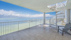 A balcony with a view of the sea, a white railing, and a spiral staircase. - HPH03 Luxury Bayfront Penthouse | Rooftop Hot Tub | Stunning Views! (Fort Walton Beach)