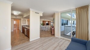 A spacious living area with a balcony, a dining area, and a kitchen. - O401 Corner Condo w/ Expansive Bay Views | Huge Balcony | Pools & Lazy River! (Fort Walton Beach)