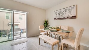 A dining area with a glass door leading to a balcony, a dining table with chairs, and a bench. - Davenport Home w/ Pool Access & Patio! (Davenport)