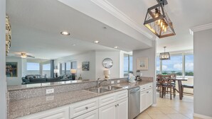 A spacious kitchen with granite countertops, white cabinetry, and a large island. - O601 Oversized Bayside Luxury | Pool Table | Lazy River & Resort Pools (Ft. Walton Beach)