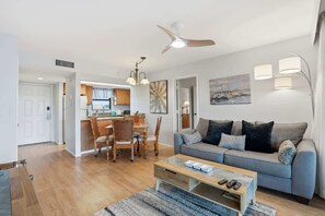 Una sala de estar moderna con sofá, mesa de centro y comedor.