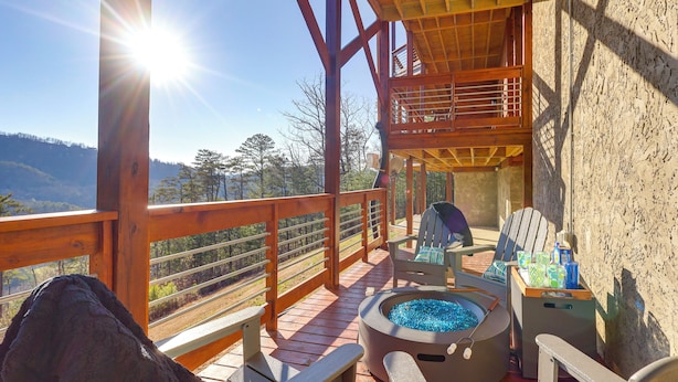A wooden deck with a hot tub, seating area, and a view of the mountains. - Majestic Mountain Views: Sevierville Escape! (Sevierville)