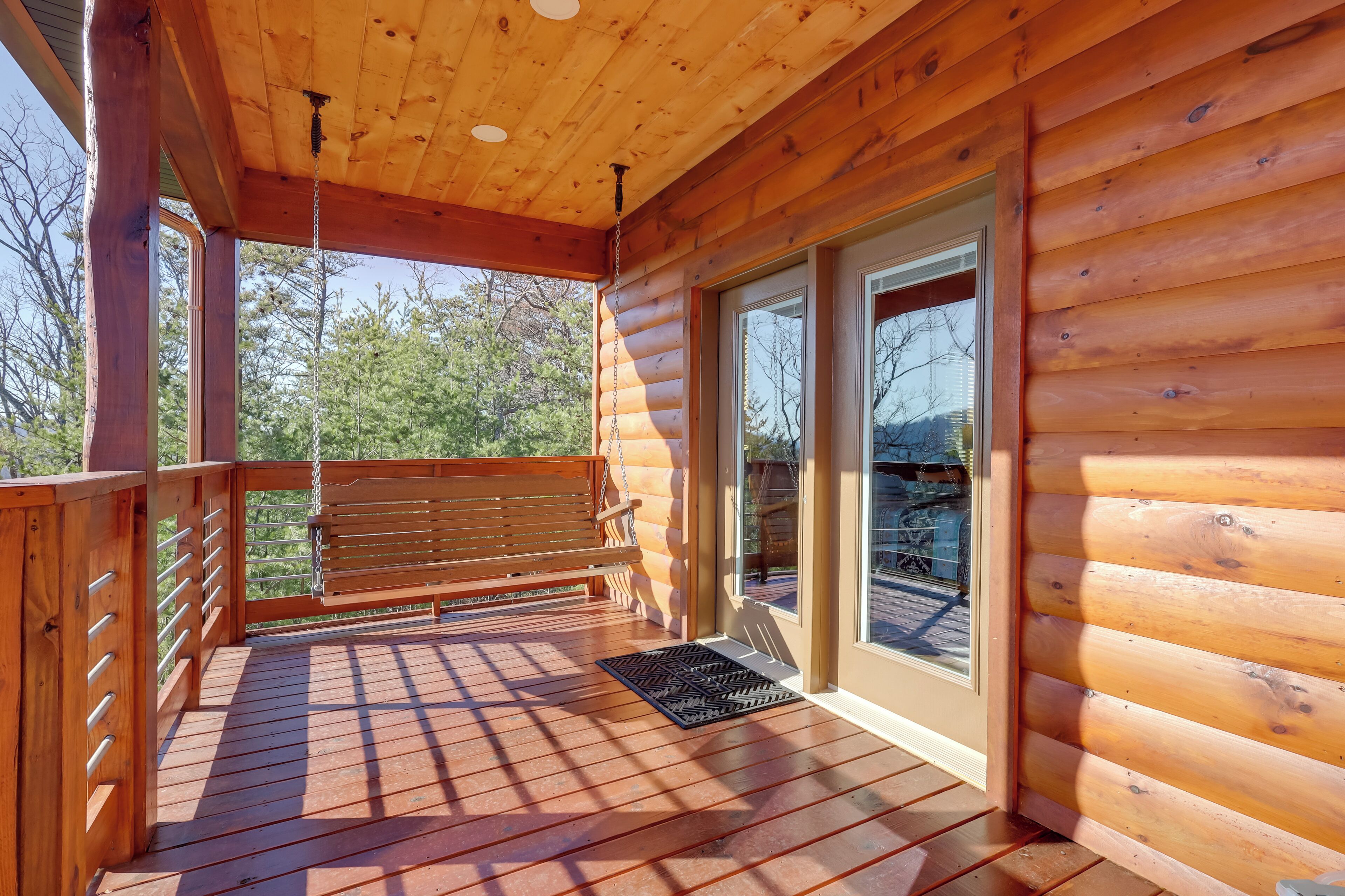 Eine Holzterrasse mit einer Bank und einer Tür zu einem überdachten Bereich.