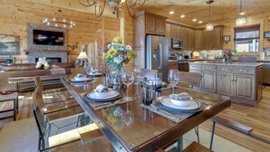 A spacious kitchen with wooden cabinets, a central island with a glass top, and modern appliances. - Majestic Mountain Views: Sevierville Escape! (Sevierville)