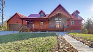 A large log cabin with a stone foundation, multiple windows, and a covered front porch. - Majestic Mountain Views: Sevierville Escape! (Sevierville)
