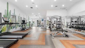 A modern gym with treadmills, weight machines, and a mirrored wall. - Chill 2BR Near ASU, Pool, Grill, Pkng, Pet Frndly (Tempe)