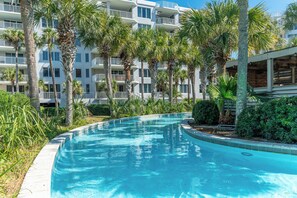 Relax by the pool surrounded by lush greenery and tropical plants.