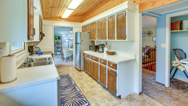A kitchen with wooden cabinets, a sink, and a microwave. - 8 Mi to Crystal Mountain: Peaceful Up North Home (Copemish)