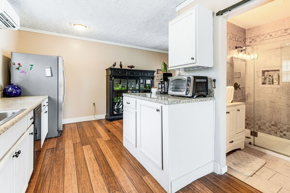 A compact kitchen with white cabinets, a built-in microwave, and a refrigerator. - 7 Mi to Lake Chatuge: Creekside Cabin w/ Decks! (Hayesville)