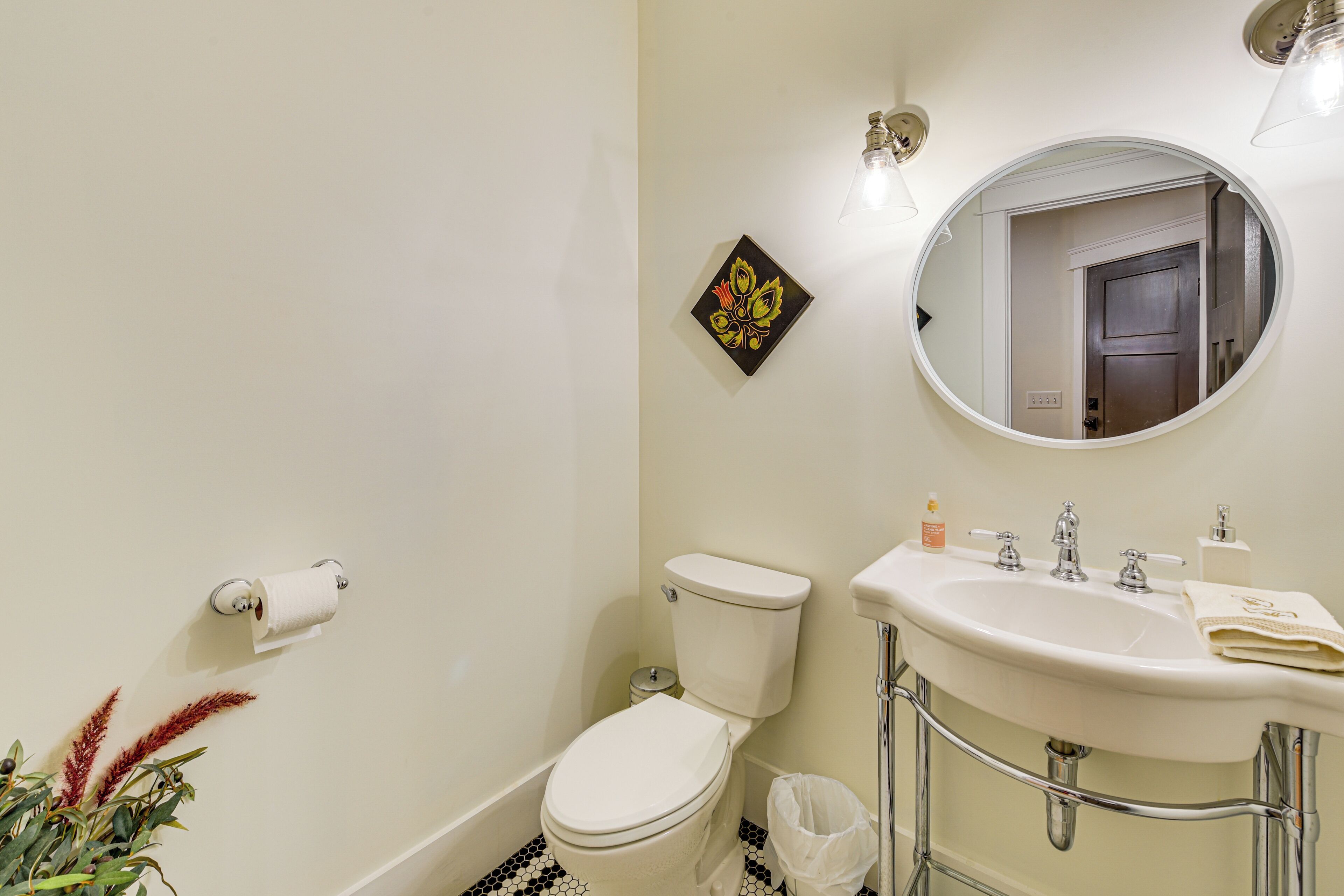 A bathroom with a toilet, sink, and mirror.