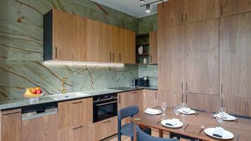 A modern kitchen with wooden cabinets, a built-in oven, and a dining area with a table set for four.
