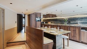 A modern kitchen with a marble countertop, wooden cabinets, and a built-in dishwasher.