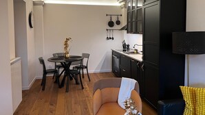 Eine kompakte Küche mit Essbereich, ausgestattet mit einem runden Tisch, Stühlen und einer kleinen Sitzecke.